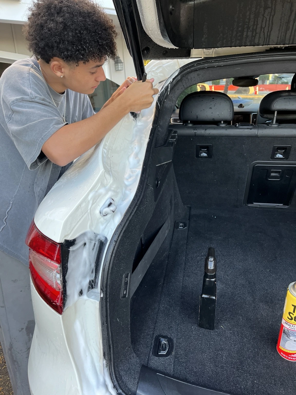 Detailing the edges of an open Maserati tailgate with a small brush