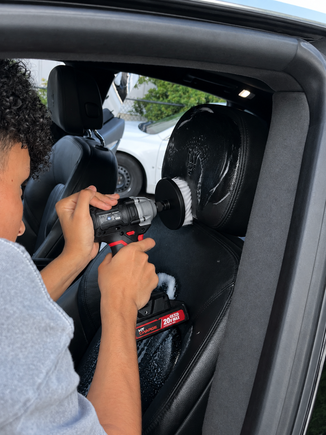 Cleaning a Maserati seat with a detailing brush